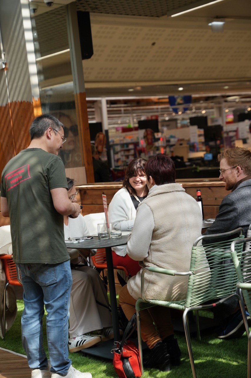 Pizzeria Corleone à Voiron, des personnes sont attablées avec un serveur. L'ambiance est conviviale.